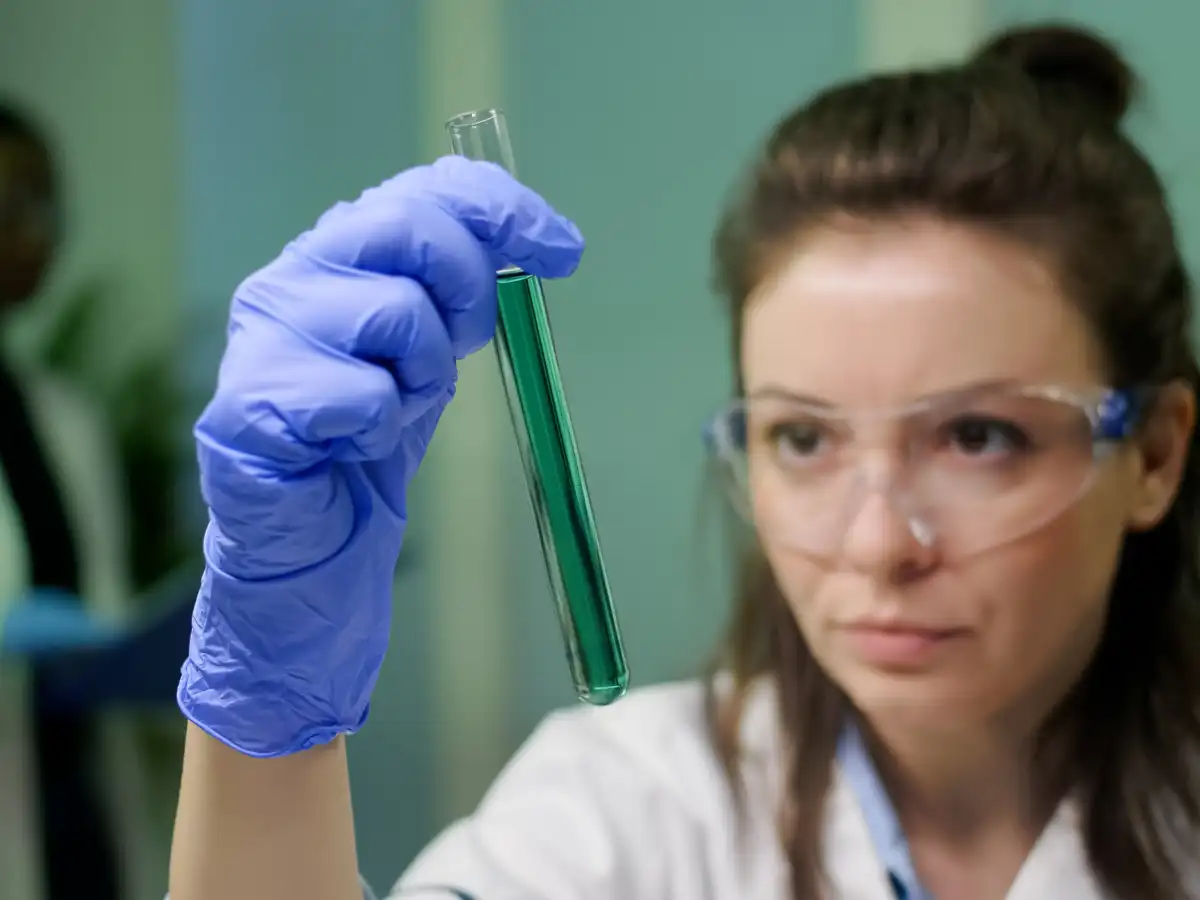 scientist woman looking at test tube with DNA sample